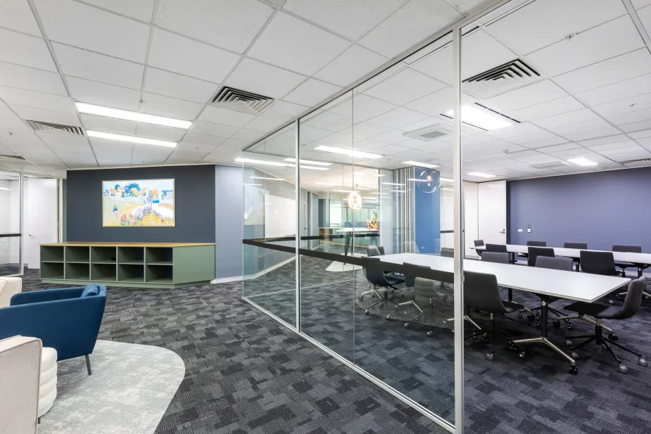 Spacious office area featuring a combination of open spaces and glass-partitioned rooms.