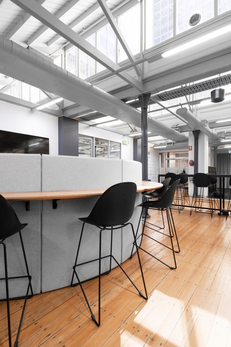 A bright and minimalist office space with a focus on a high counter seating area. 