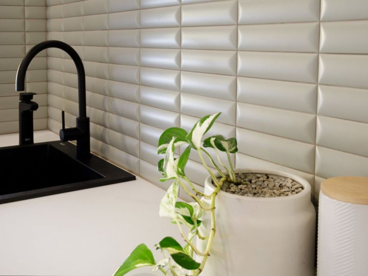 Close-up view of a modern kitchen sink area with a matte black faucet and black sink basin.